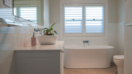 white tiled bathroom with freestanding bath