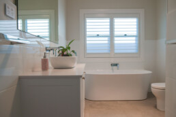 white tiled bathroom with freestanding bath