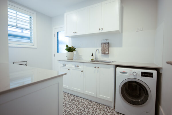 modern spacious white laundry with moroccan style grey floor tiles