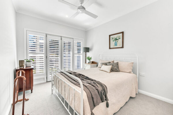 White spacious bedroom with plantation shutters