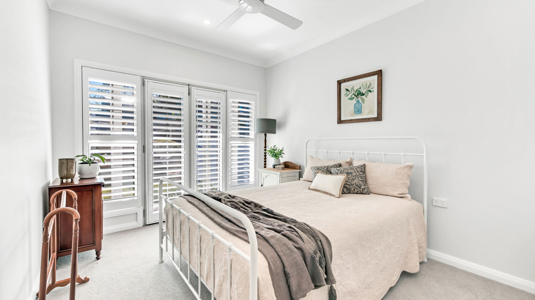 White spacious bedroom with plantation shutters