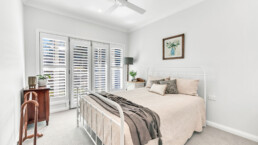 White spacious bedroom with plantation shutters