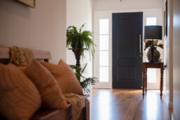entrance to home, wooden floorboards and black painted front door