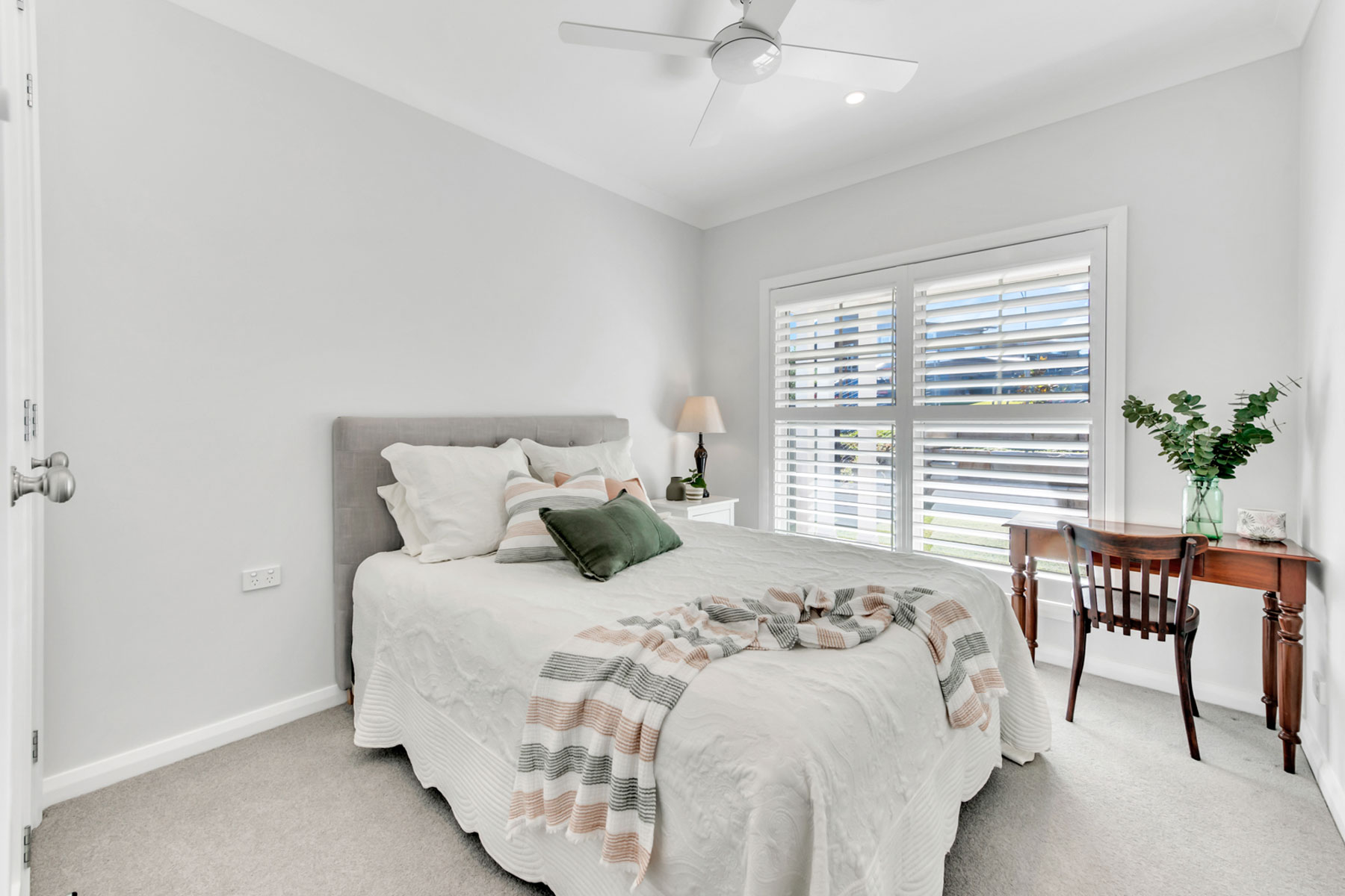 white spacious bedroom with plantation shutters