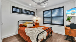 bedroom with black framed windows and rustic double bed