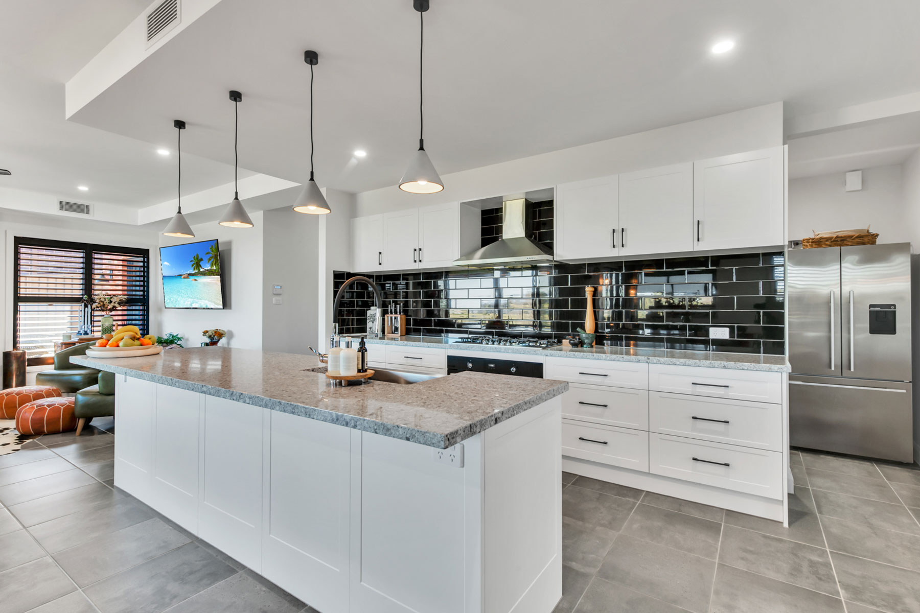 white gallery style kitchen with black tiled splashback