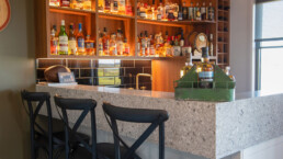close up of bar with bar stools and liquor cabinet