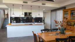 dining area looking into kitchen with black tiled splashback